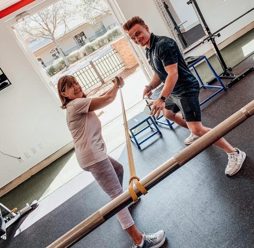 A trainer working with a client using a resistance band
