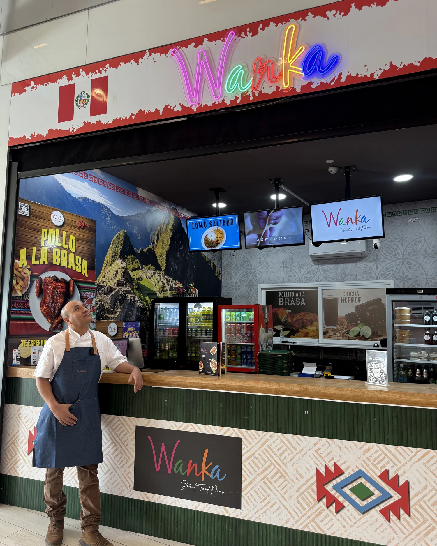 Interior de WANKA Leganés, con el neón, el mural y Fernando en la barra
