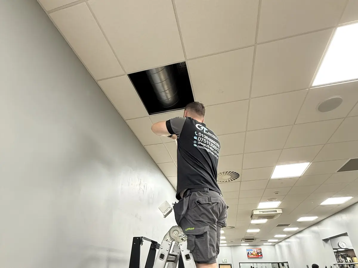 CT Electrical commercial electrician working on a ceiling installation in a gym
