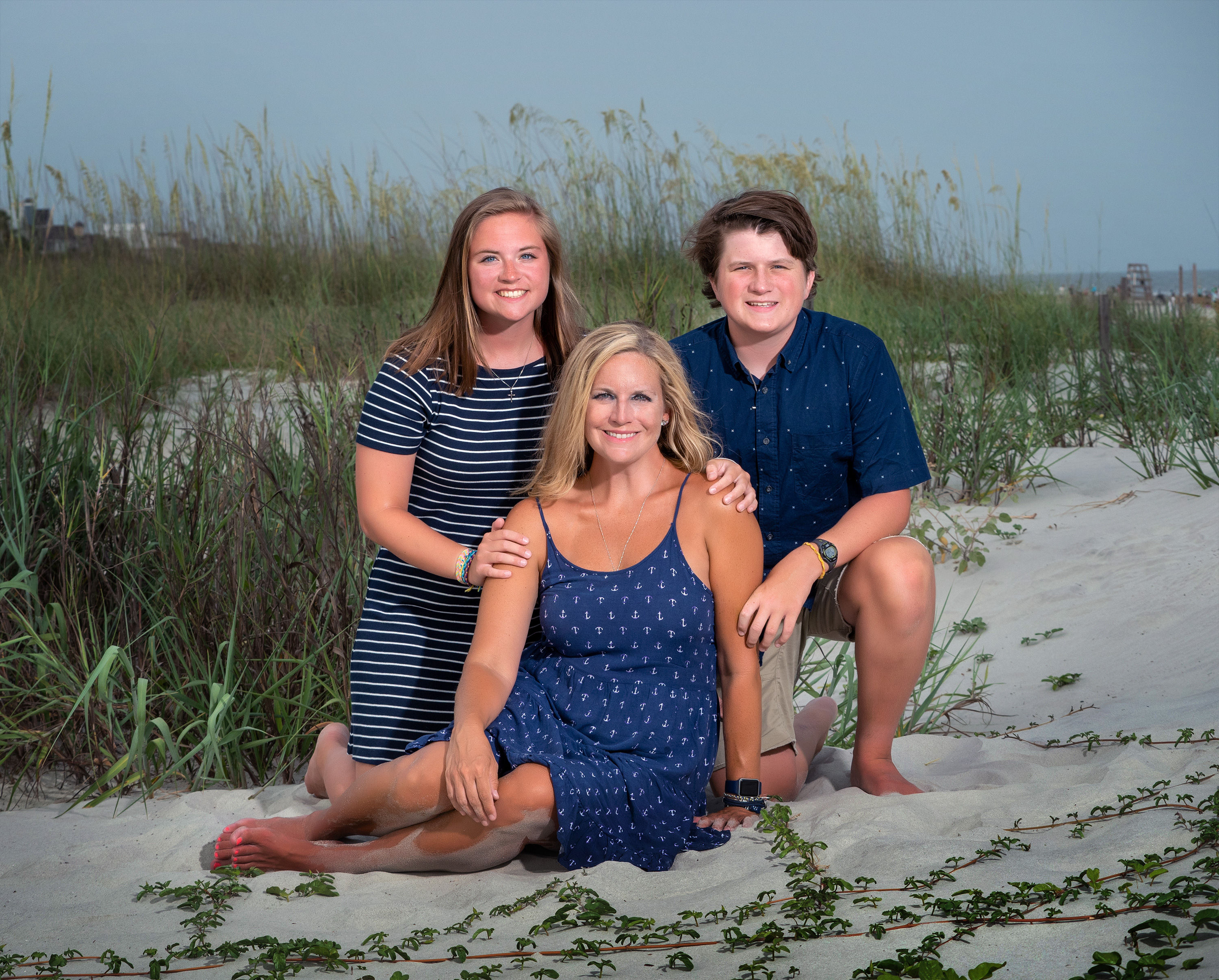 Mother and her teenage son and daughter posing together on Hilton Head beach among sand dunes, Fish Haul Beach.