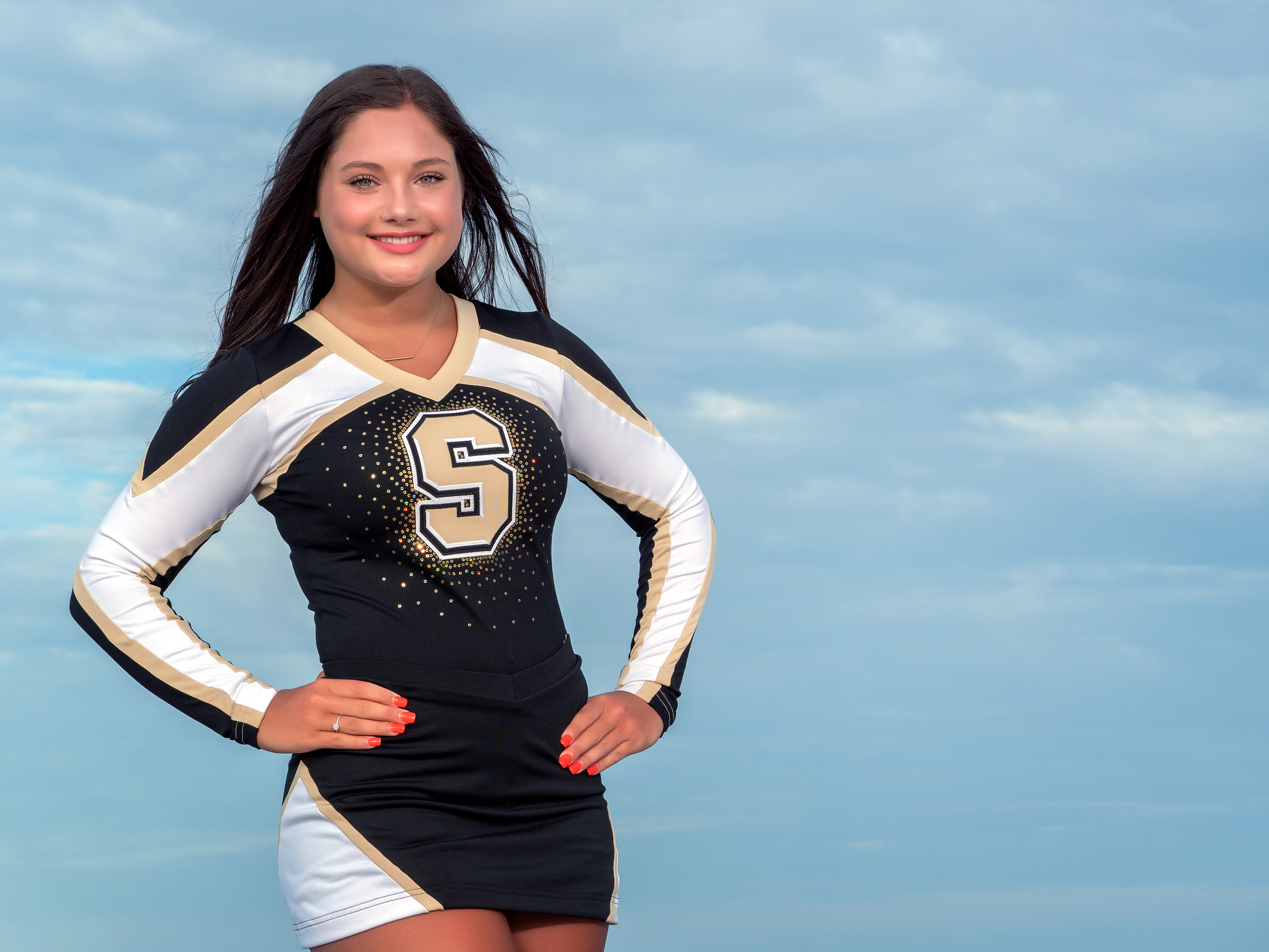 Hilton Head senior portrait of high school cheerleader in uniform during beach photo session