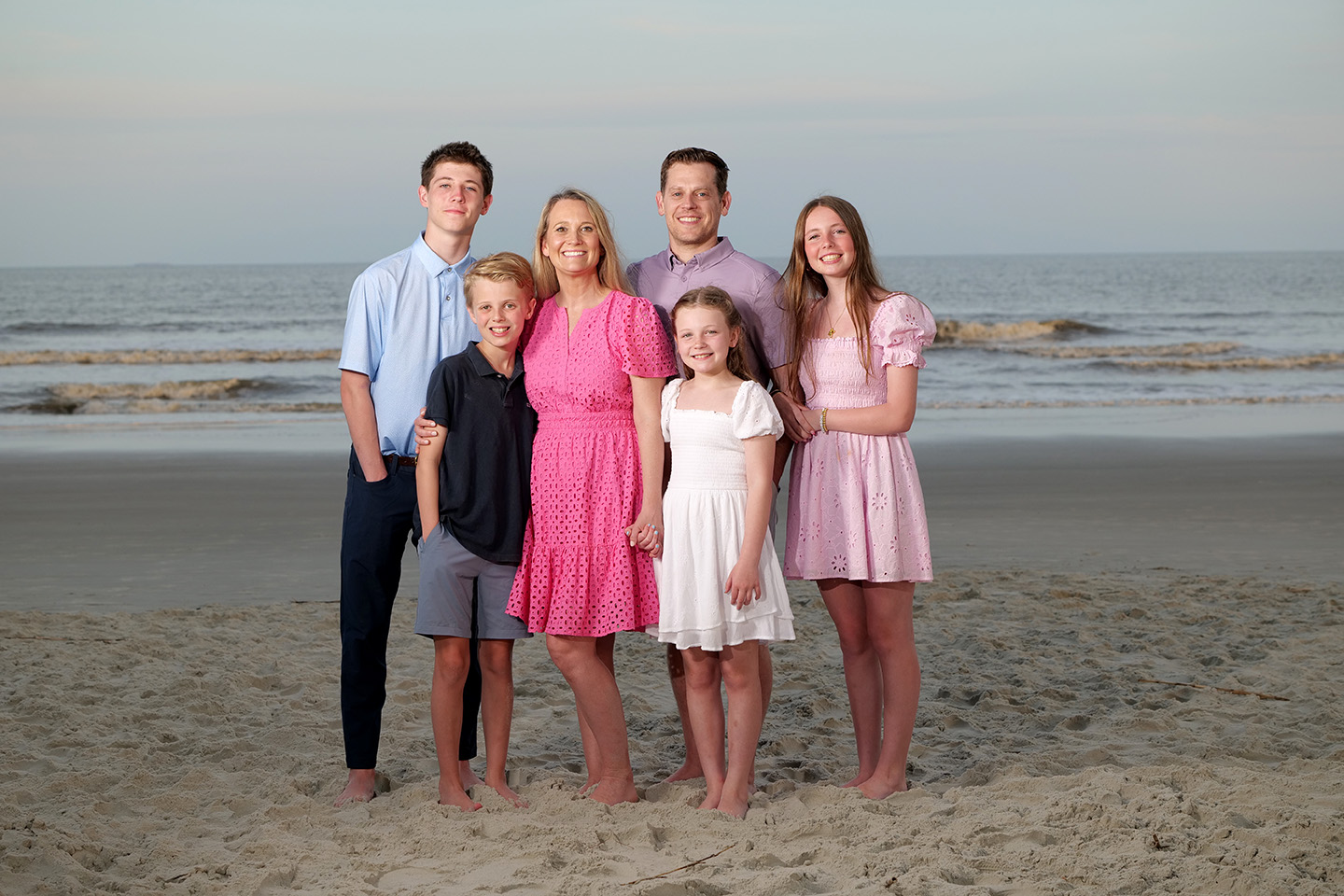 Family of six standing together on the beach at sunset during a Hilton Head Island photography session