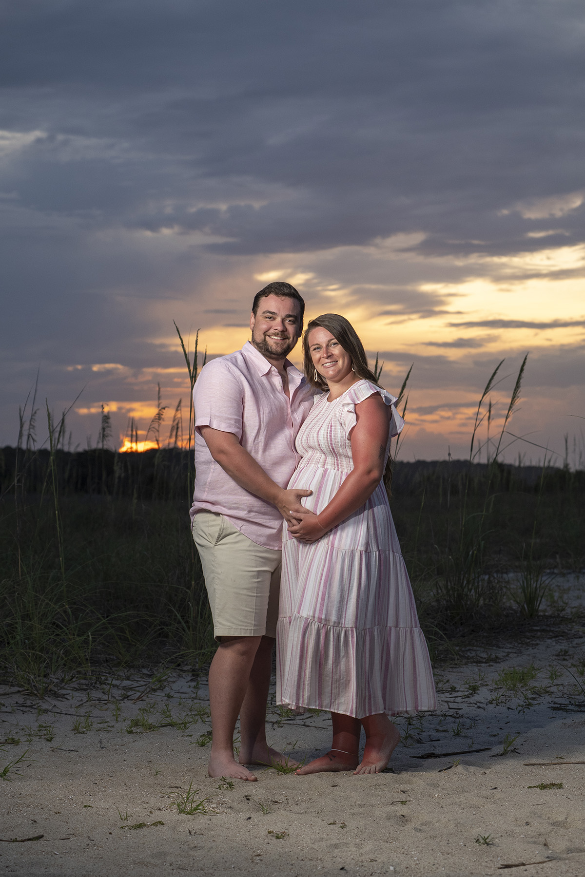 Couple holding baby bump during a maternity beach photo session at sunset on Hilton Head Island