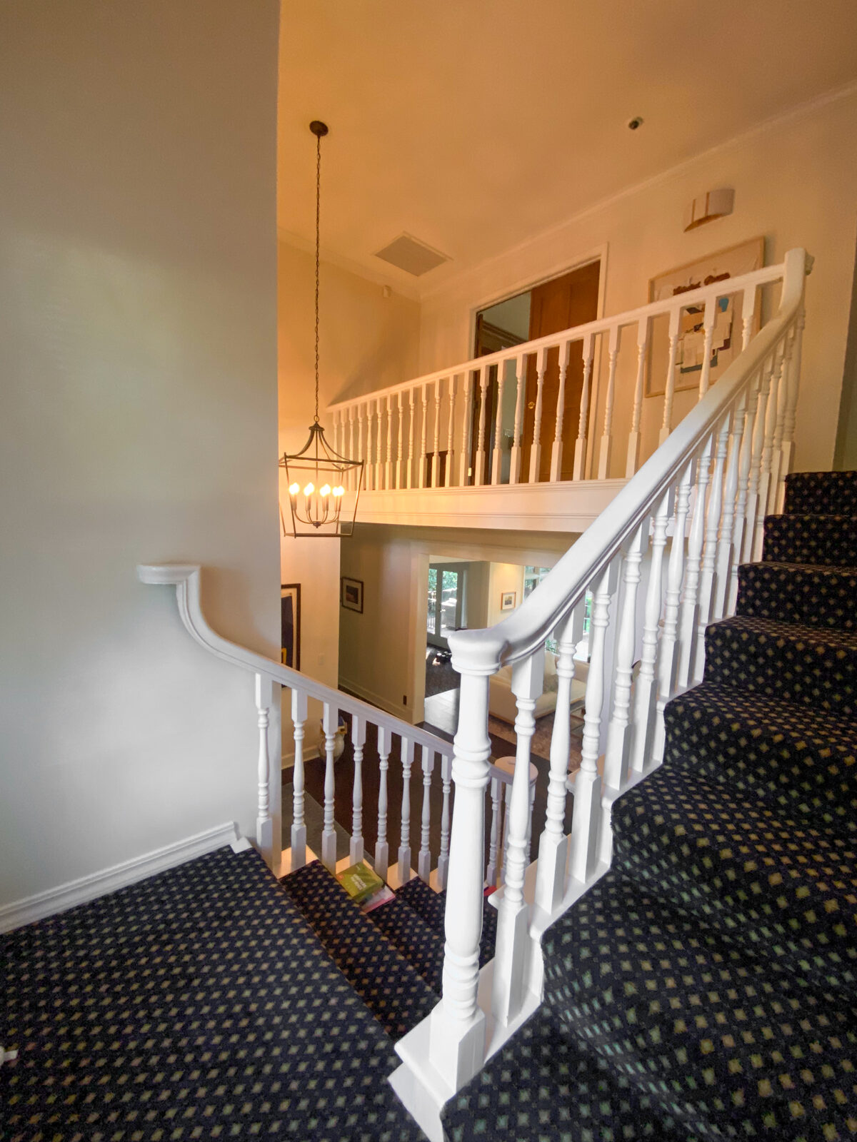 Staircase with patterned carpet and white spindles before remodel, Rocklin CA