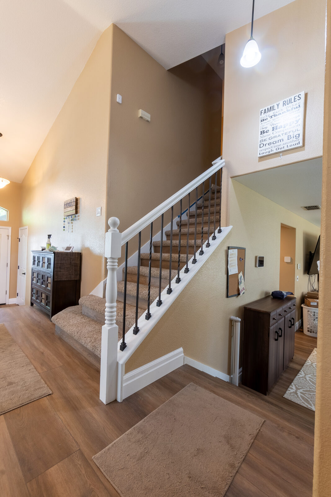 Staircase with white balusters and stained wood handrail, Rocklin CA