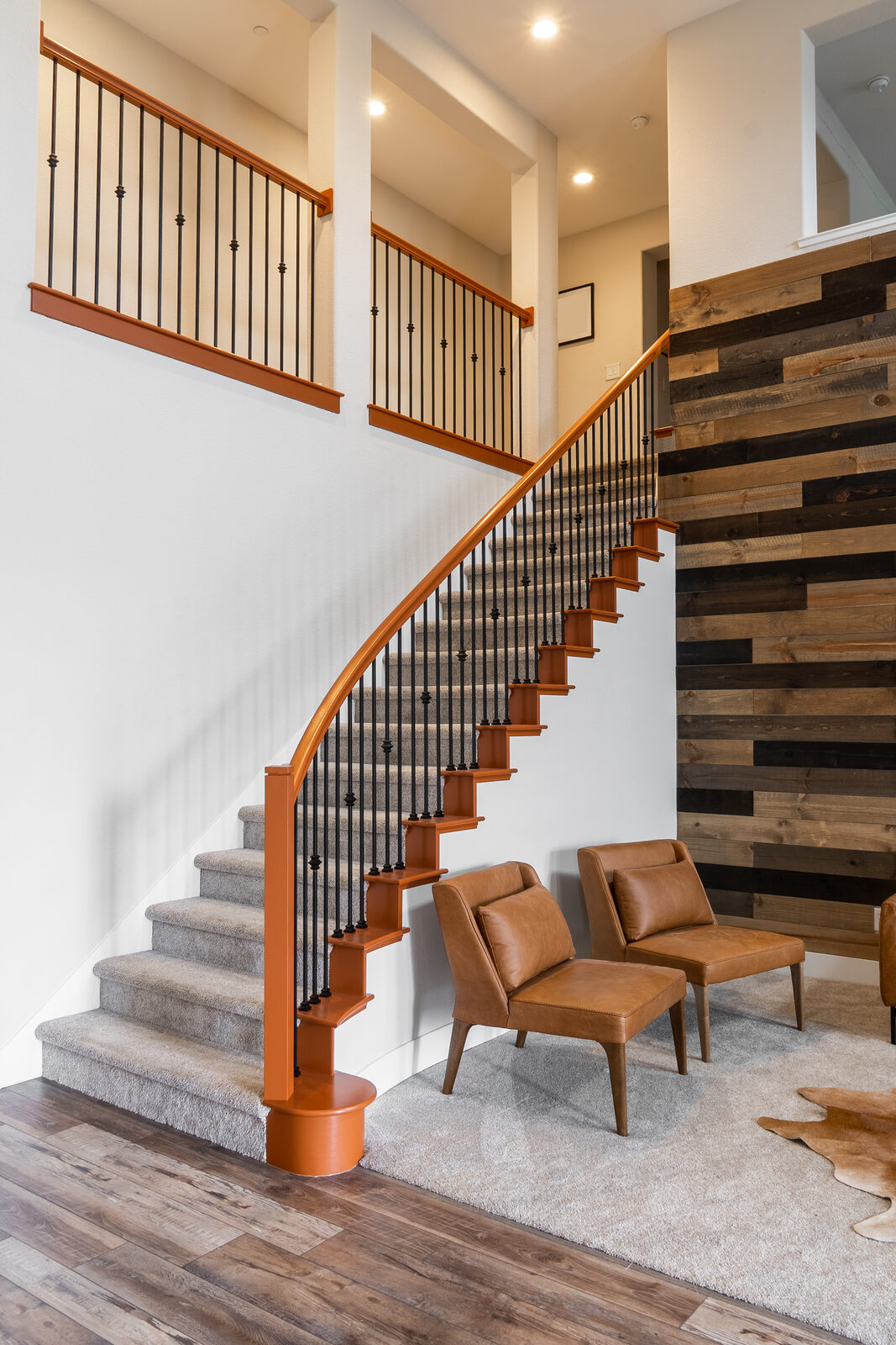 Curved staircase with iron balusters and wood plank accent wall, Granite Bay CA