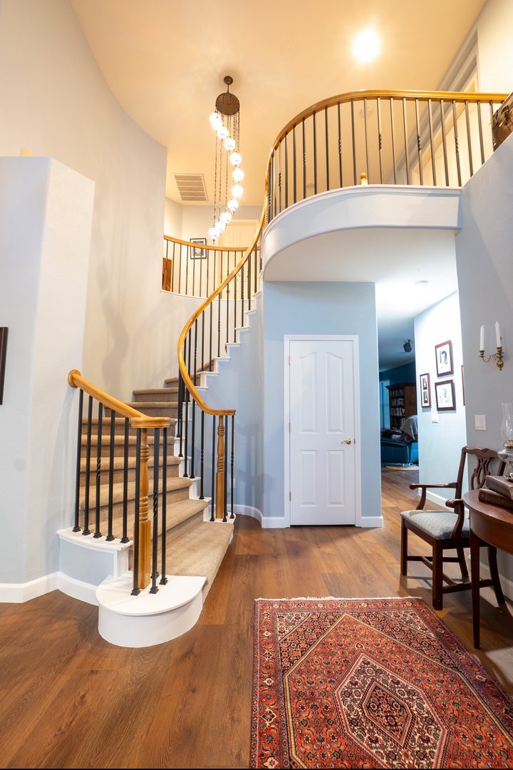 Staircase modernized with new black wrought-iron balusters, keeping the home's existing stained wood handrail and posts — Roseville, Northern California