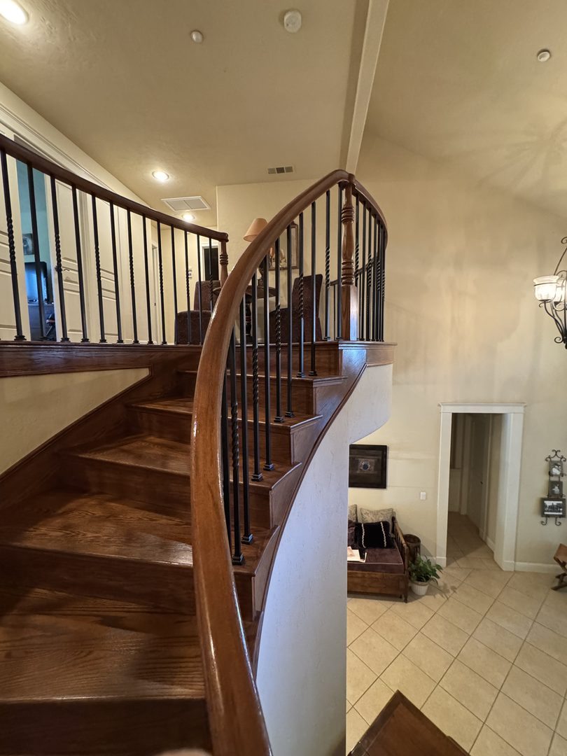 Updated staircase with new wrought-iron balusters and the home's original wood rail and newel post — Northern California