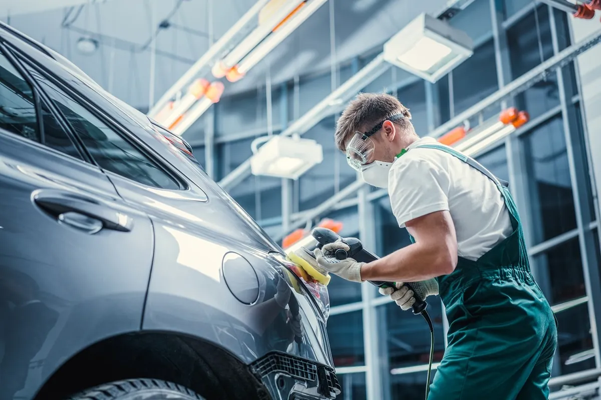 Technician performing auto body repair on a car at Classic Collision