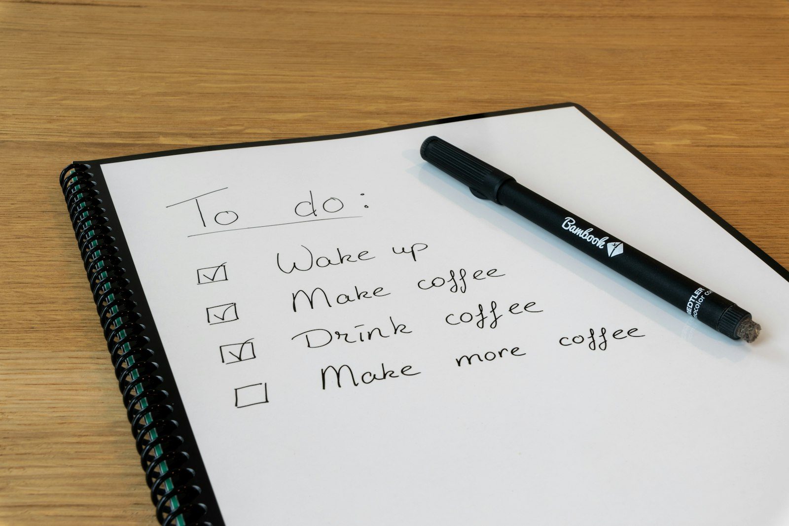 A notebook with a handwritten to-do checklist and a pen