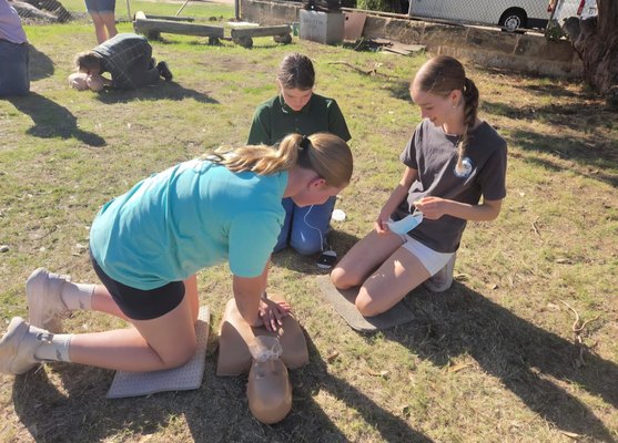 Participants practising wound bandaging in pairs at a REACHAU first aid course