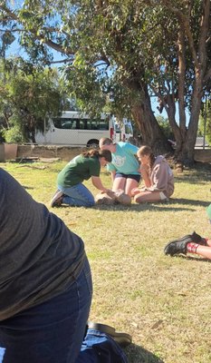 First aid scenario practice during a REACHAU HLTAID011 course, participants working together on a simulated casualty