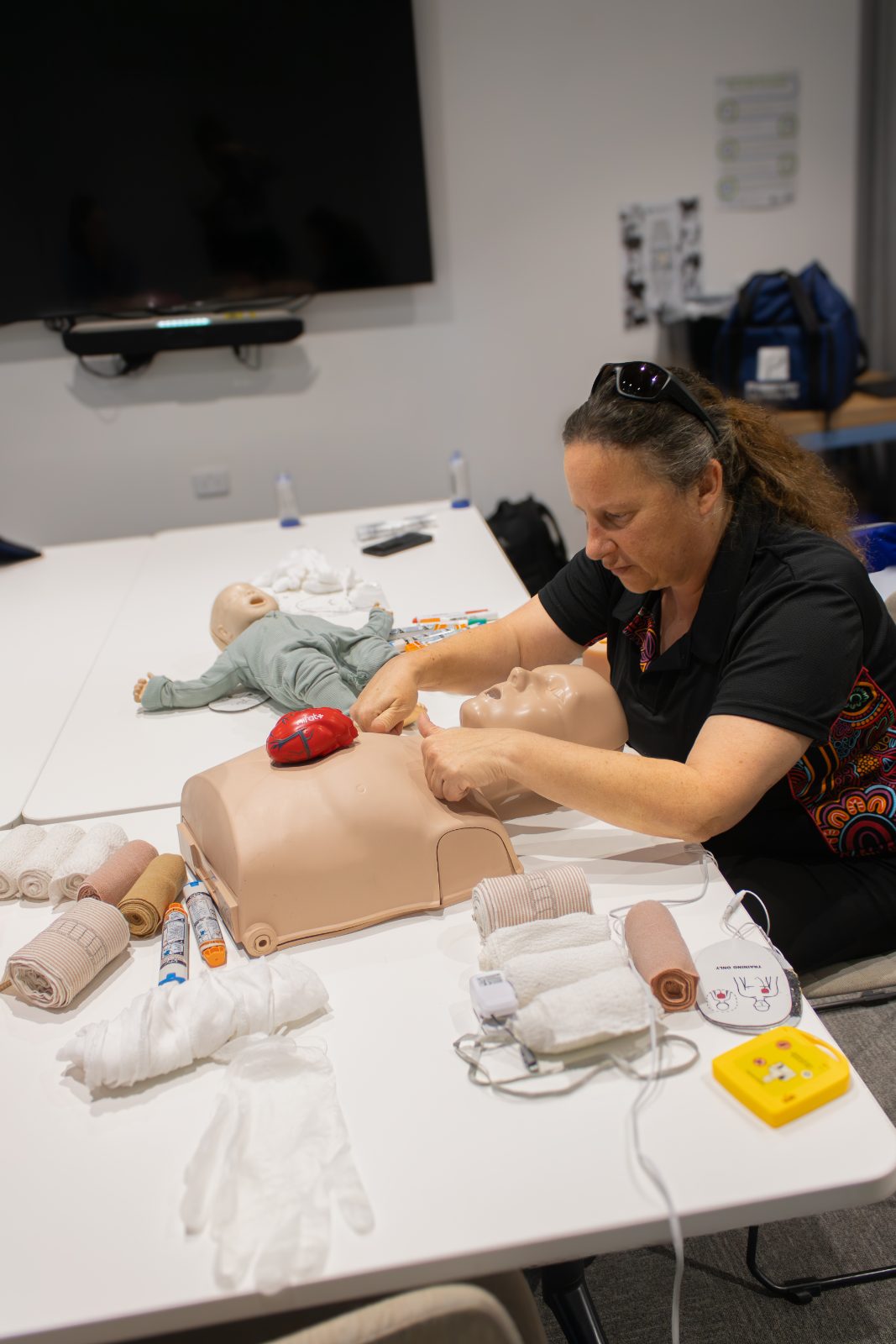 Britt Brennan checking the airway and breathing of an adult manikin during training