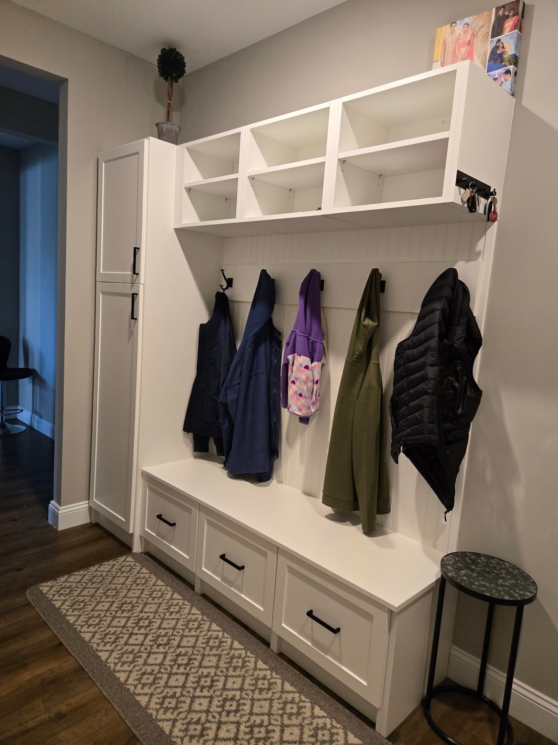 White mudroom with cubbies, coat hooks and a bench
