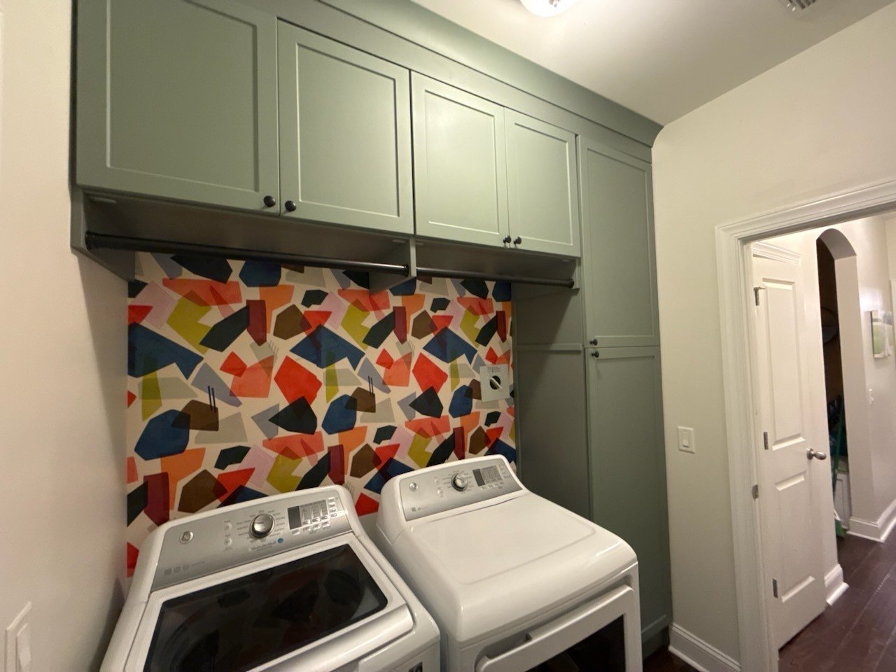 Laundry room with sage shaker cabinets above the washer and dryer