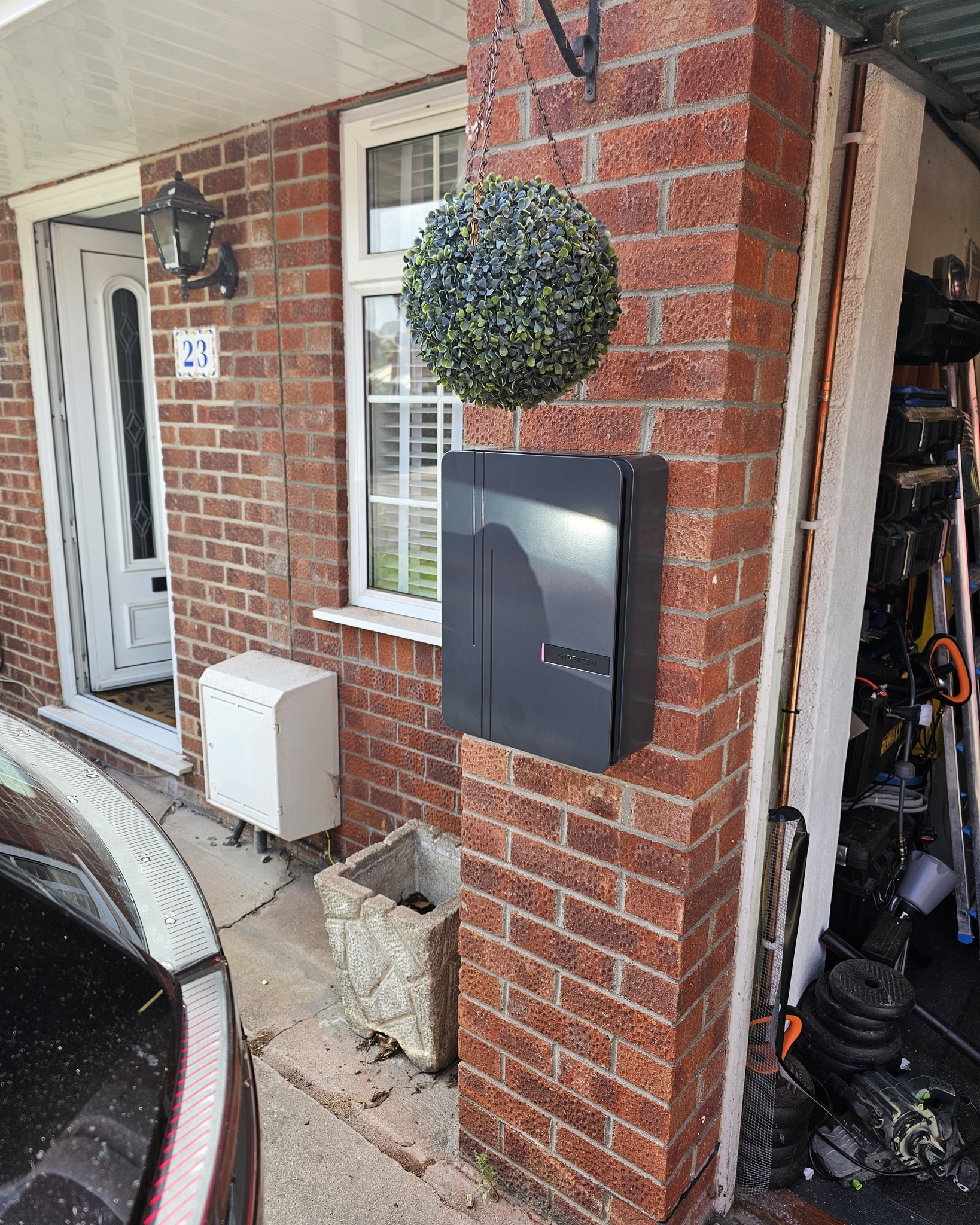 EV charger fitted on a wall with a car on the driveway in North Somerset