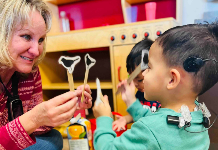 Child with cochlear implants participating in listening and spoken language therapy at Children Pediatric Audiology in Phoenix.