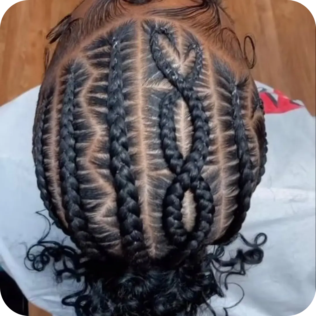 Intricate stitch braids with a custom heart-shaped design and long curly bohemian ends, professionally styled at Sweetie's Inn Braid and Loc Salon in Montreal.