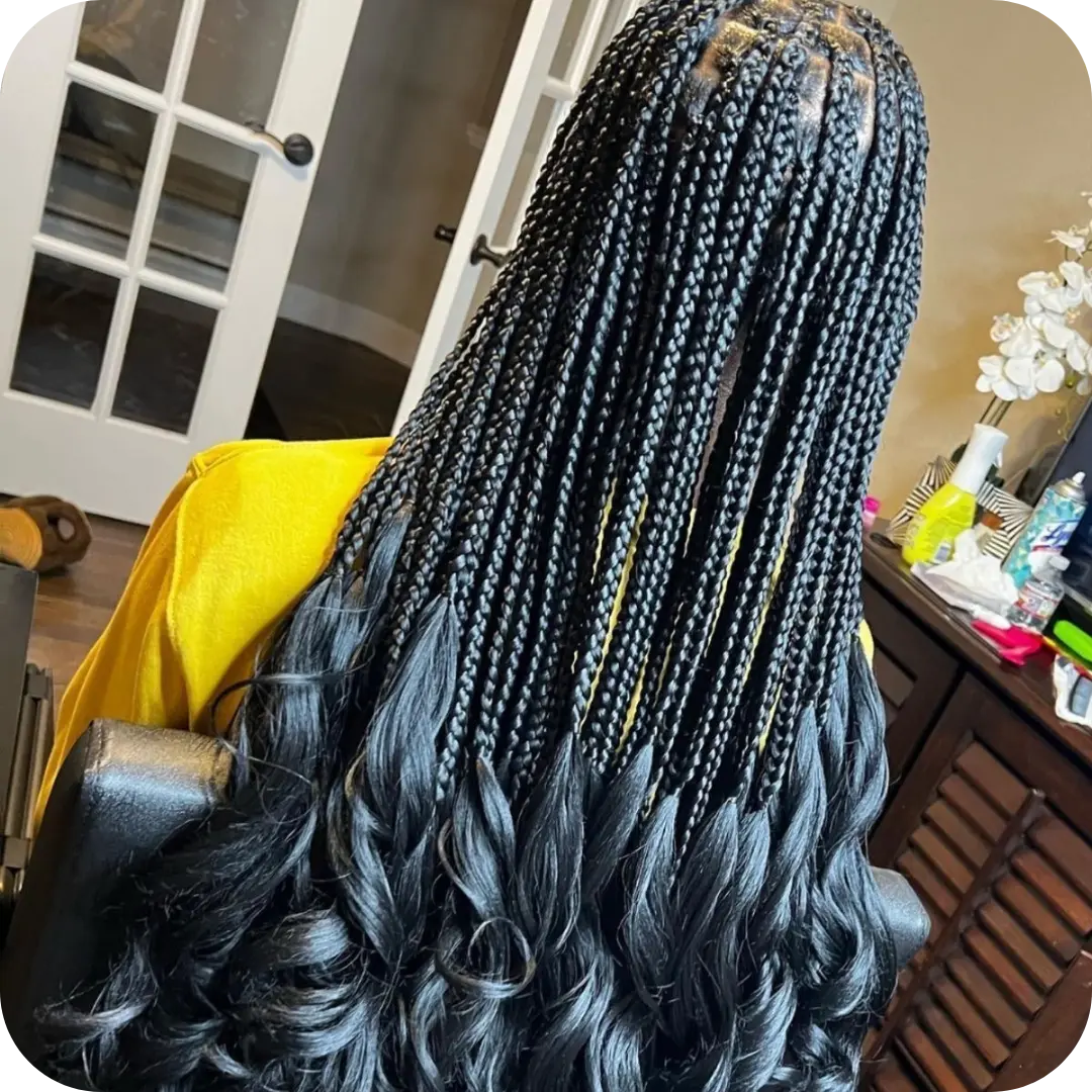 Back view of long knotless braid extensions with silky French curl ends, a premium protective style at Sweetie's Inn Braid and Loc Salon in Montreal.