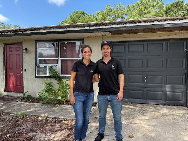 Manny and Hailey in front of the first house they flipped