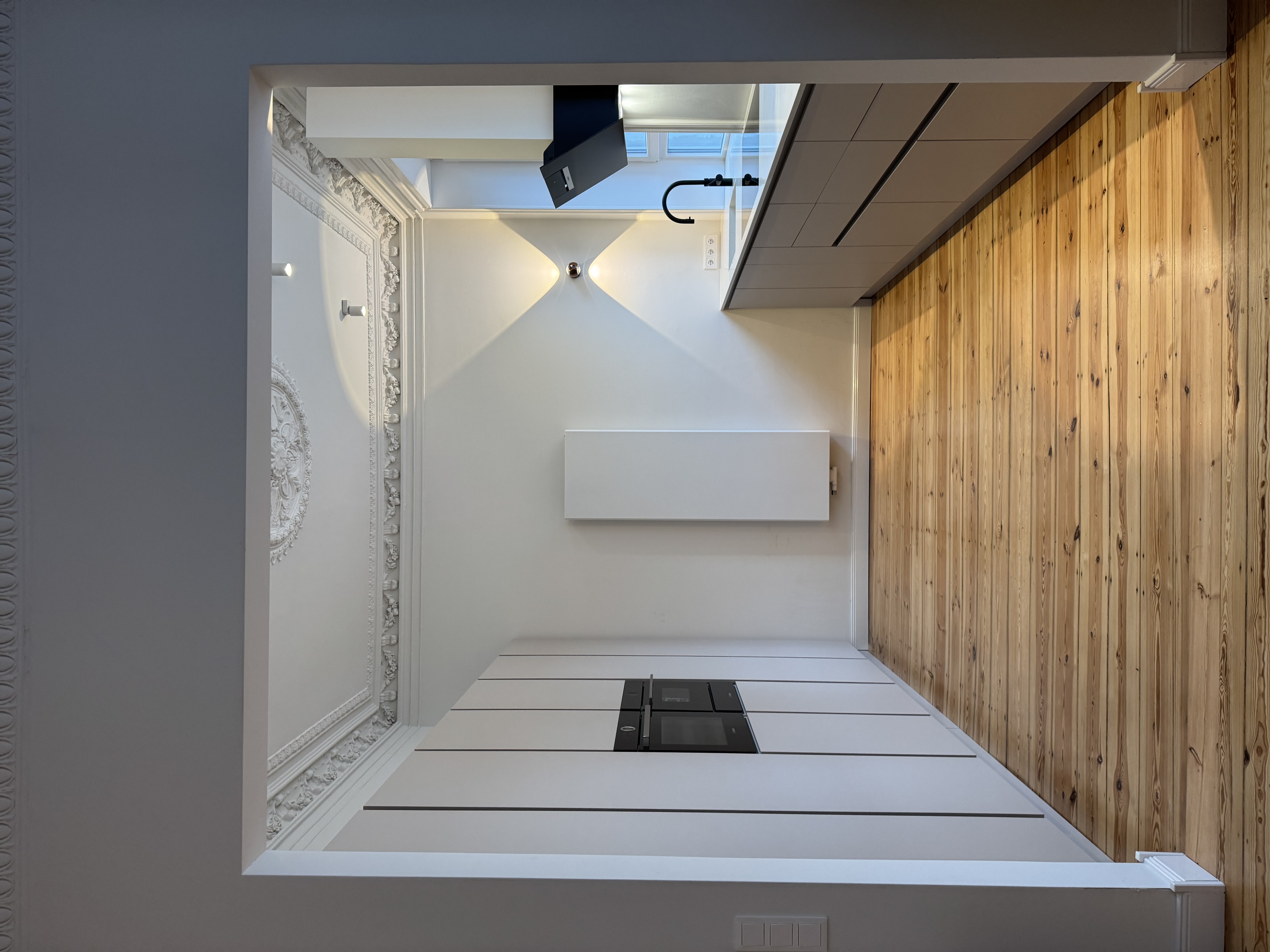 Moderne Küche im Altbau mit Stuckdecke, Holzboden und schwarzer Armatur