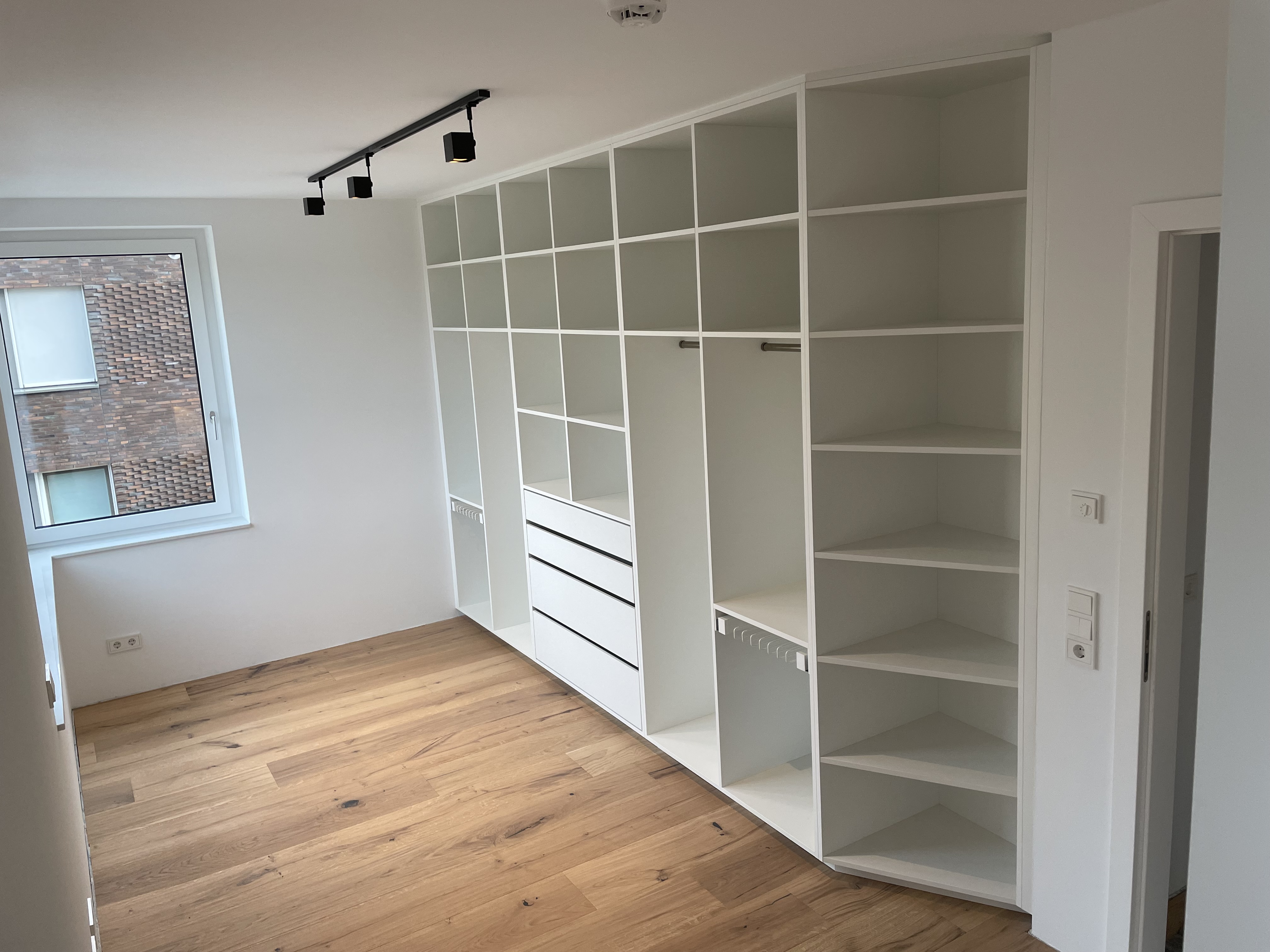 Offenes Regalsystem mit Schubladen und Kleiderstange als begehbarer Kleiderschrank