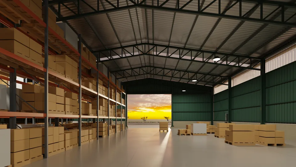 Interior de un galpón con racks, pallets y el portón abierto al atardecer