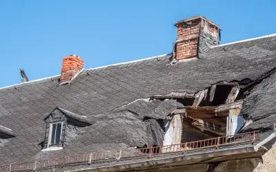 Severe storm roof damage on Round Rock, TX home with broken shingles and exposed structure