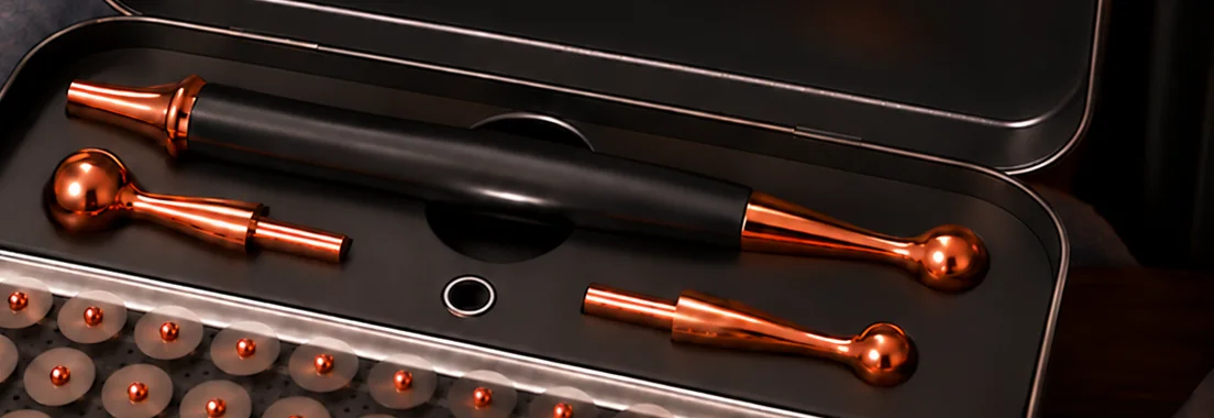 Close-up of the Reset Wand in its kit: magnetic tip on the left, black handle, copper ball end on the right, with two spare copper ball heads