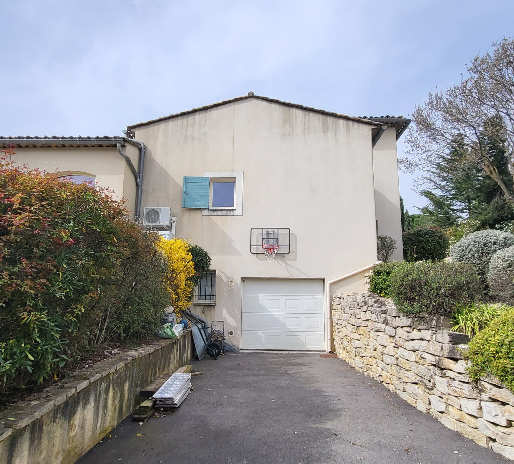 Pignon d'une maison à étage couvert de traces de ruissellement grises depuis la toiture, avant nettoyage