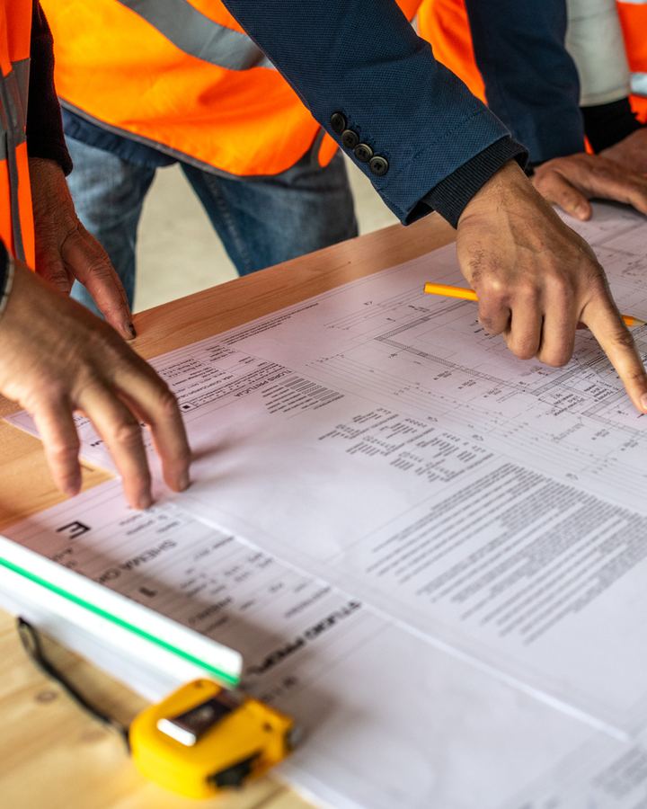 Builders reviewing plans on a job-site table