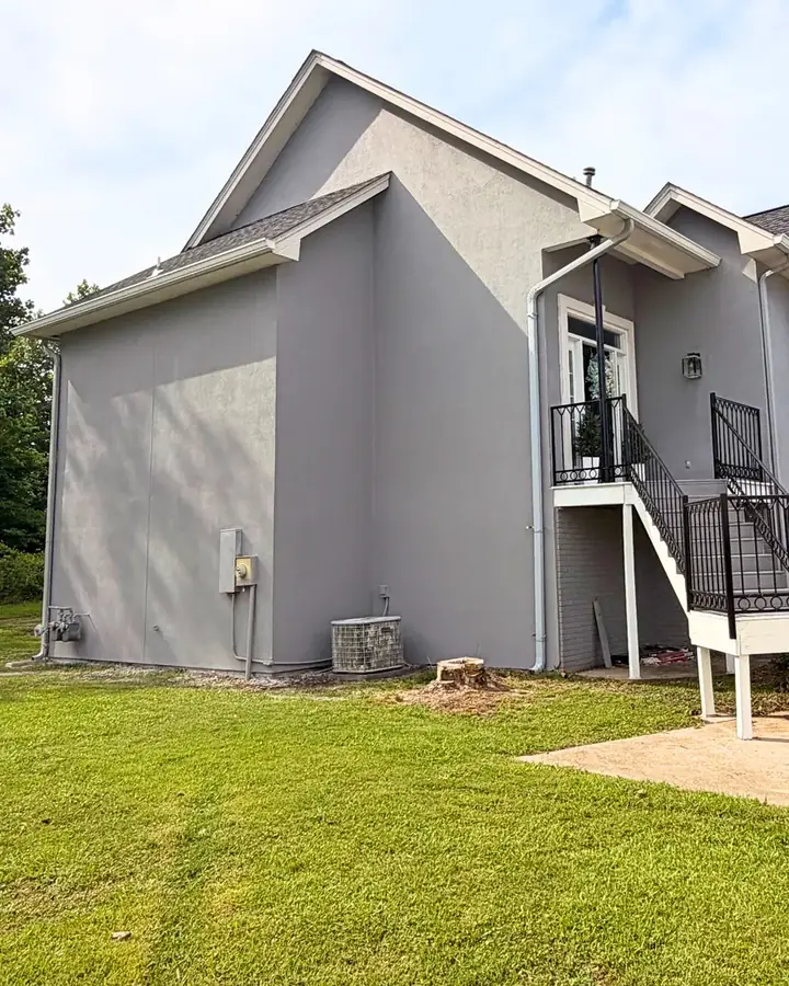 After: repaired and refreshed gray stucco exterior on the two-story home
