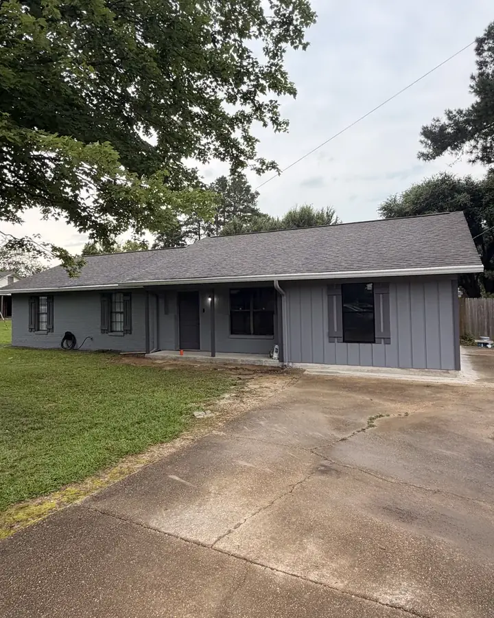After: completed home addition with gray board-and-batten siding and new windows
