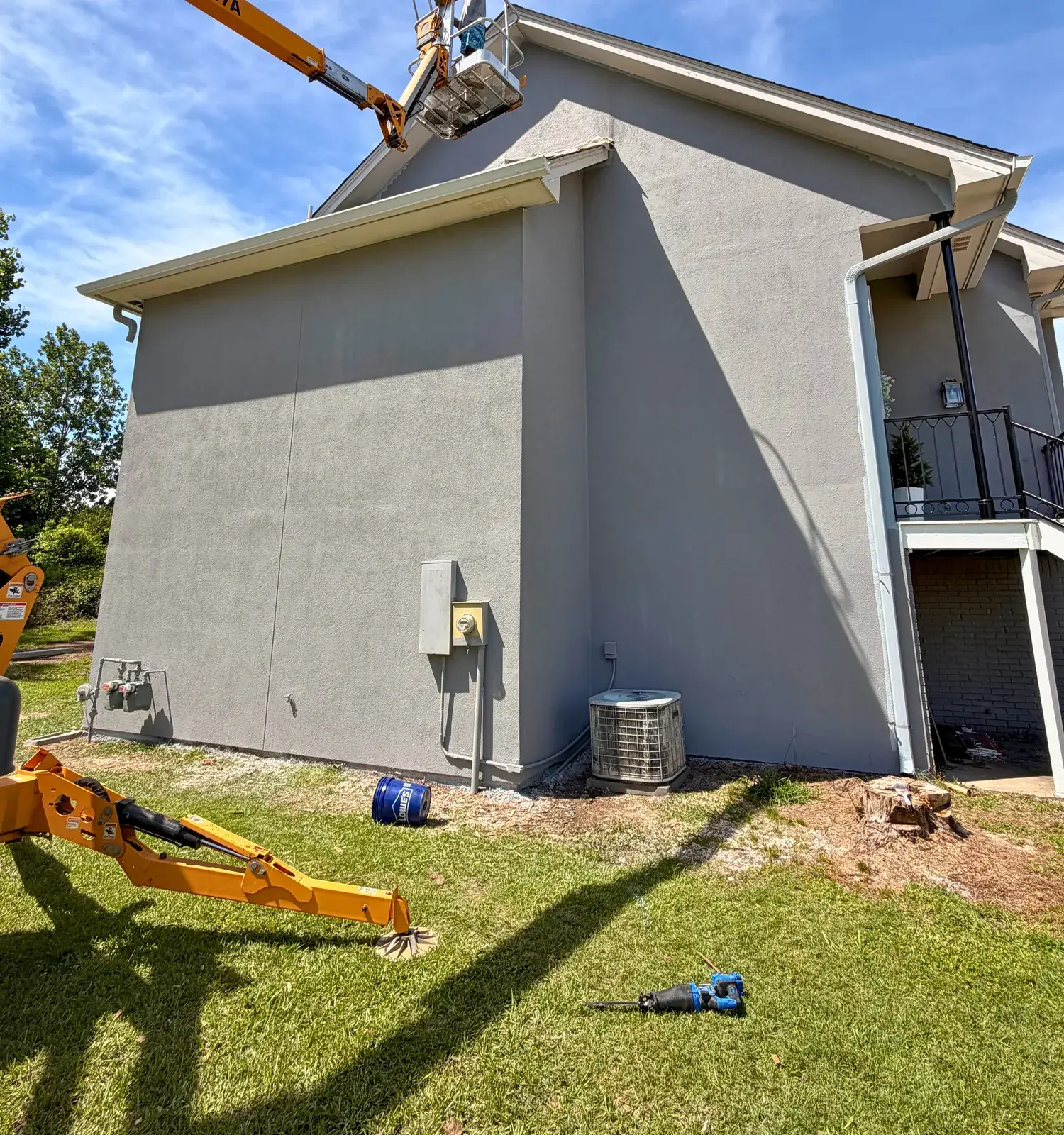New stucco finish being applied to the side wall of a two-story home in Starkville, Mississippi