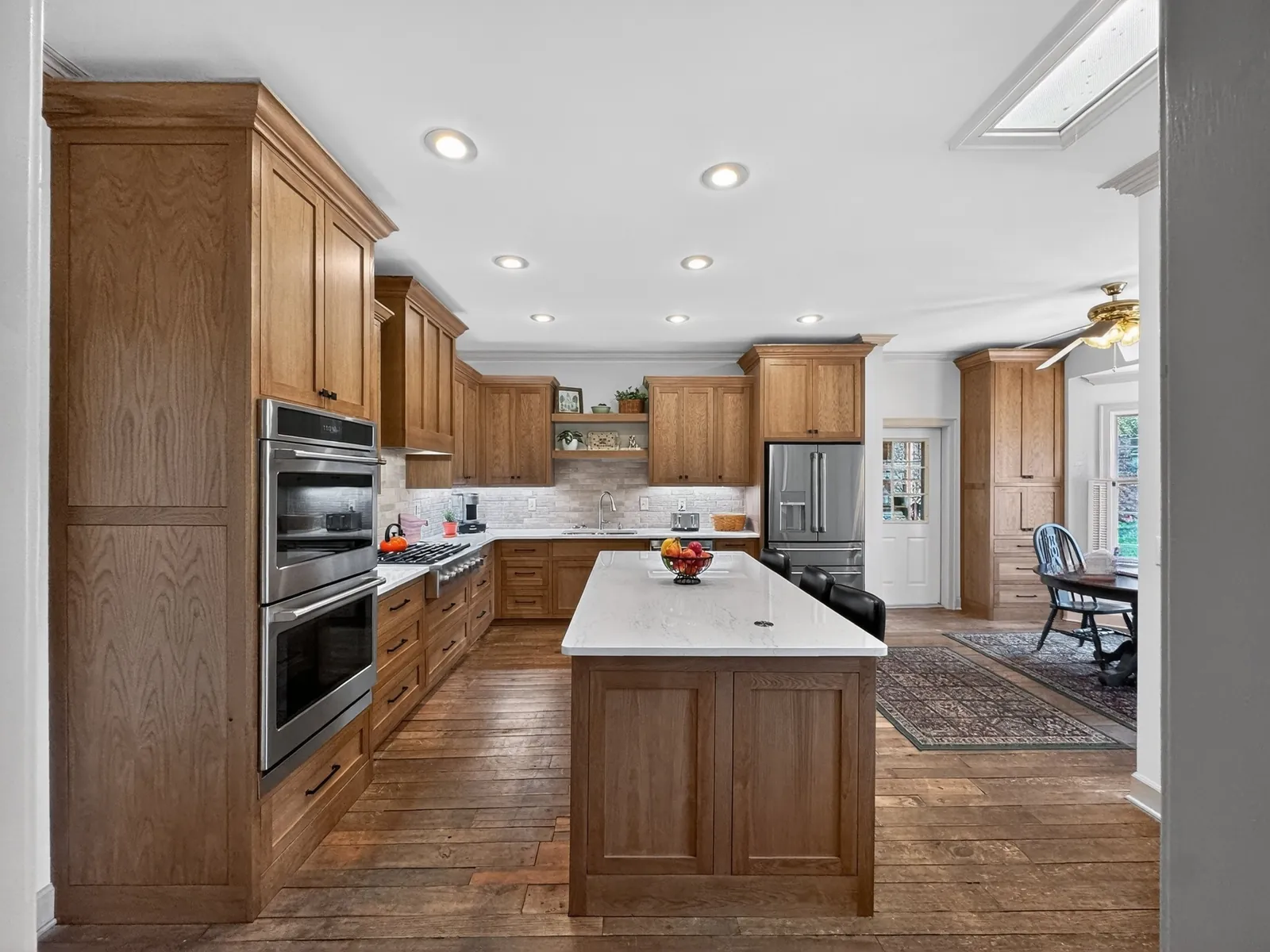 Remodeled kitchen with wood cabinets, a double wall oven and a large center island in Starkville, Mississippi
