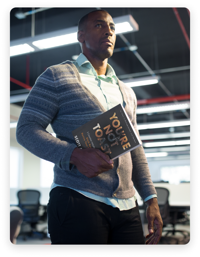 Photo of a man holding a copy of You're Not Toast