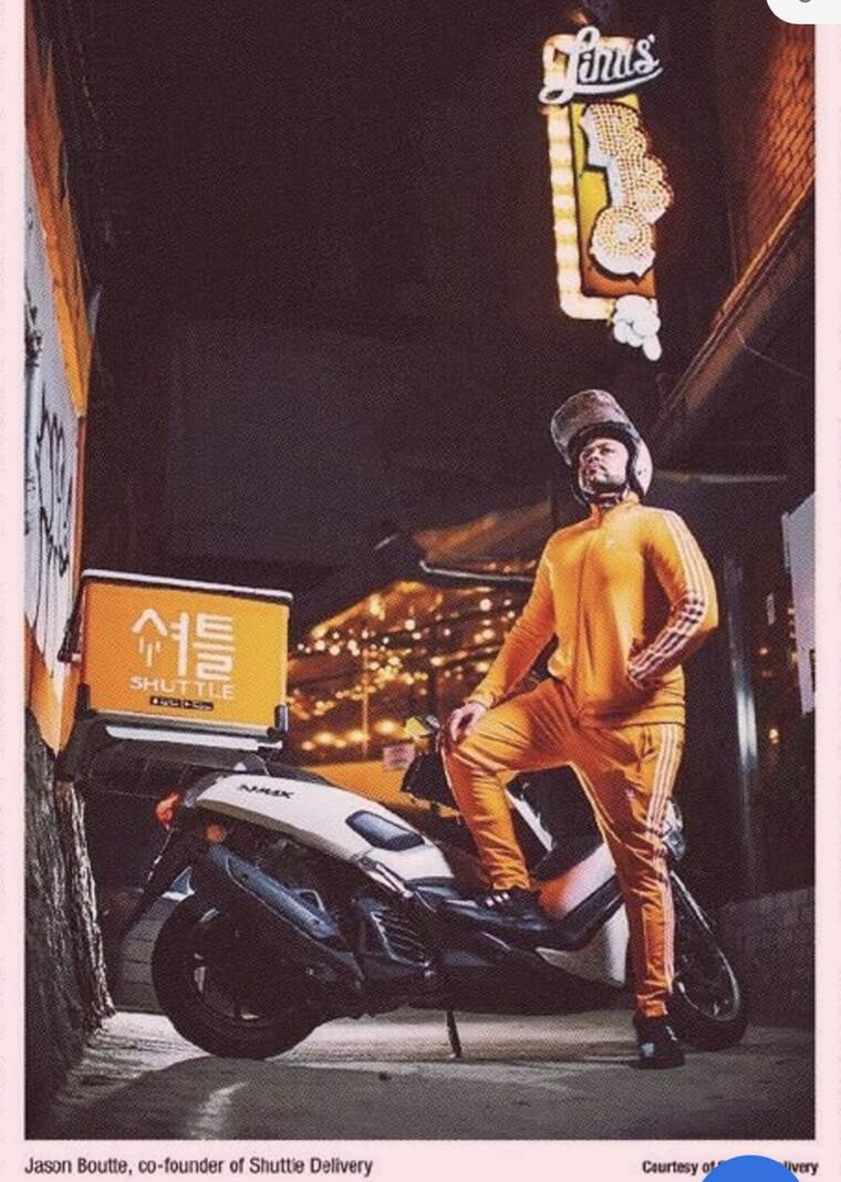 Jason Boutte with a Shuttle Delivery scooter in a Seoul alley