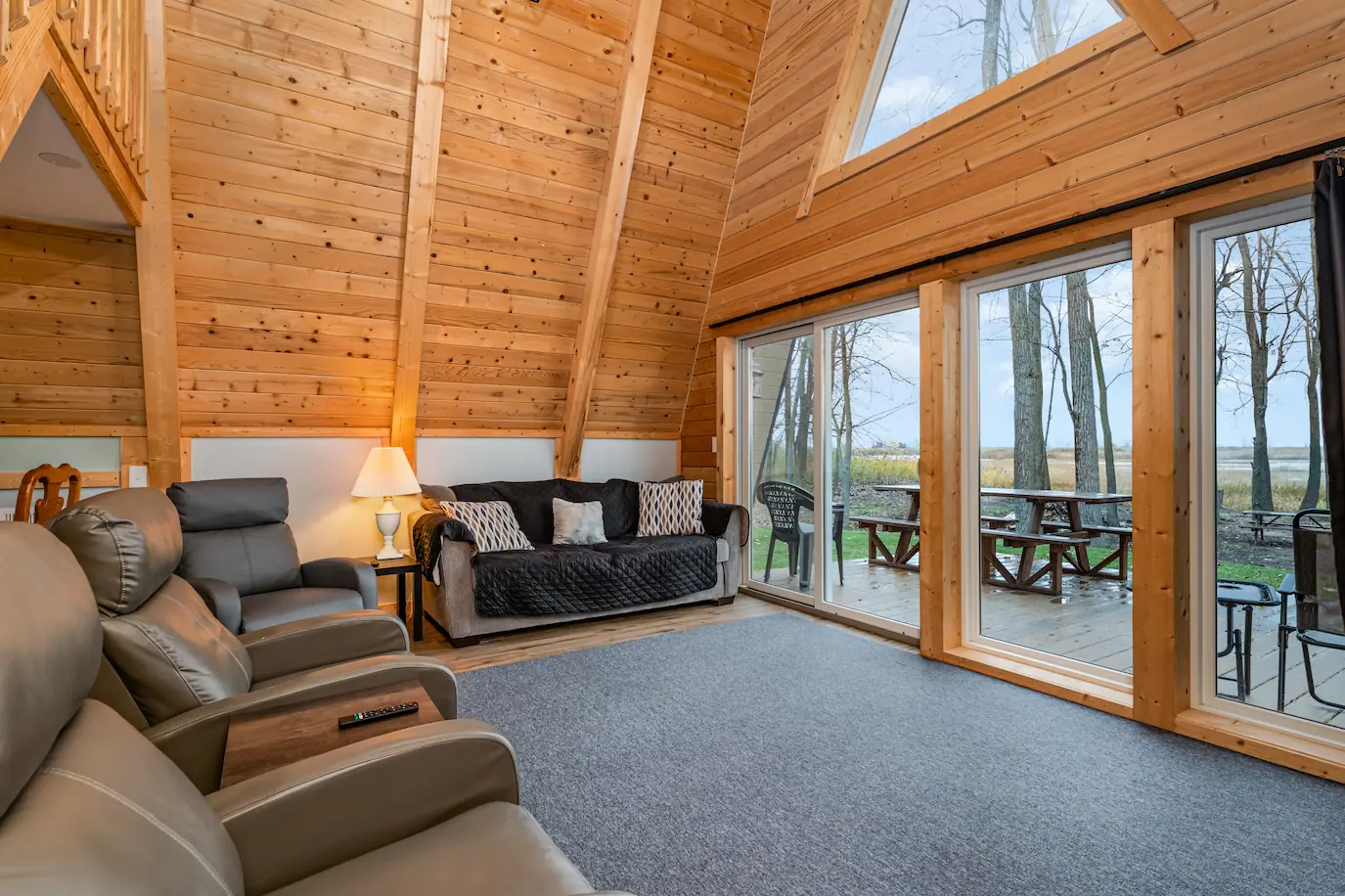 Classic A-Frame living room featuring soaring windows and lake view