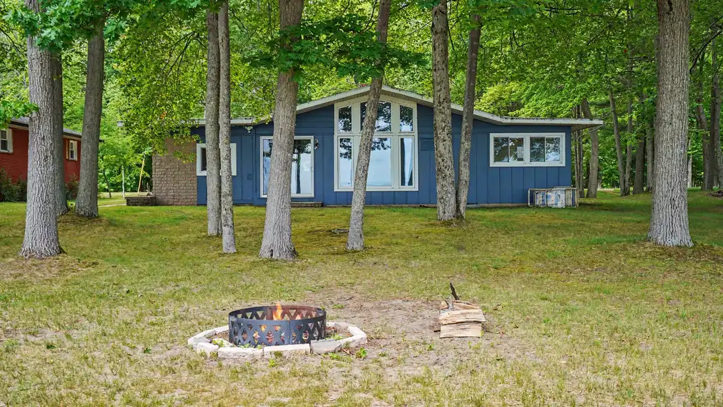 Lakefront exterior of Granny's Cabin with fire pit