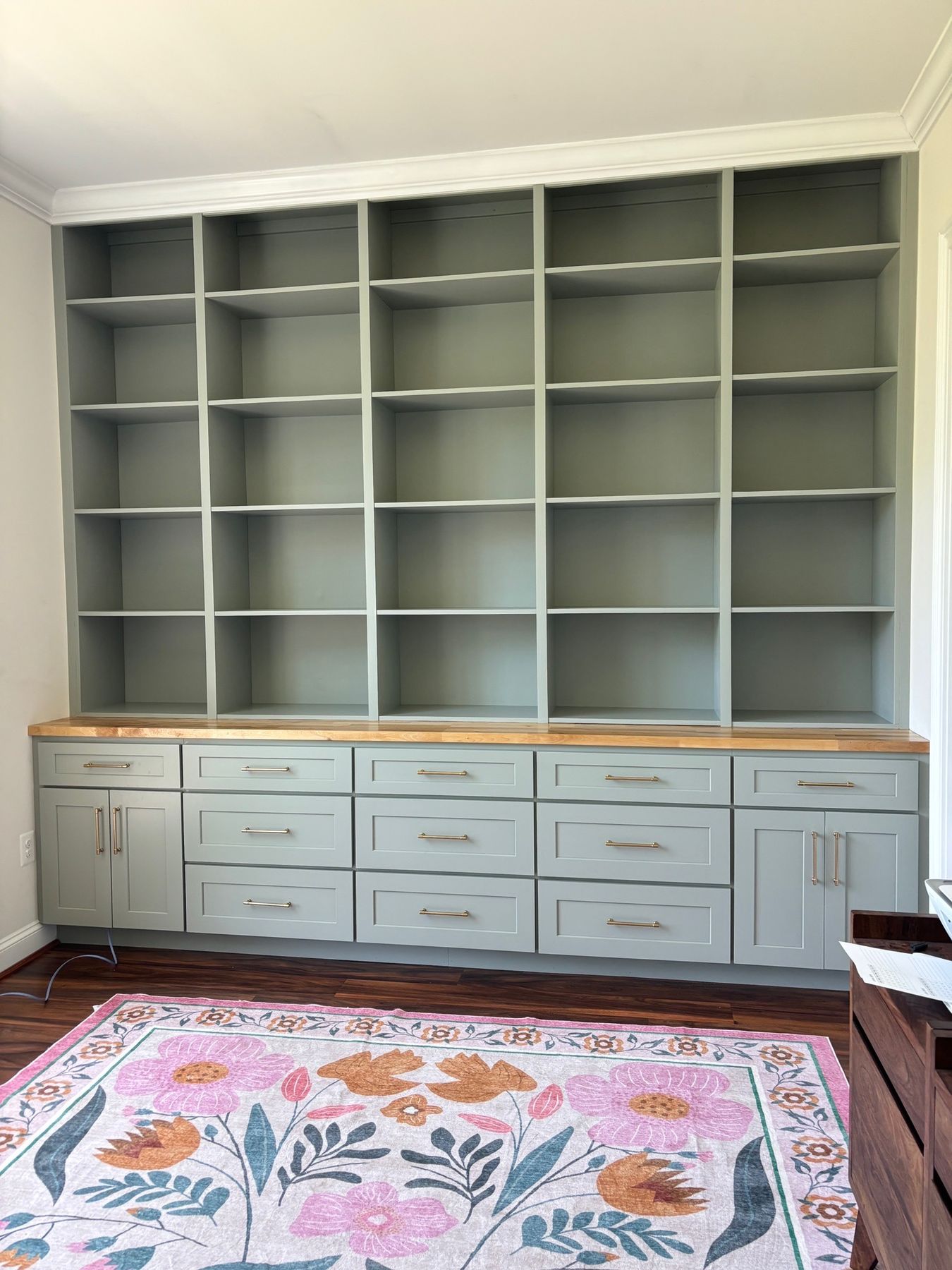 Custom built-in shelving and cabinetry, sage green paint with wood top