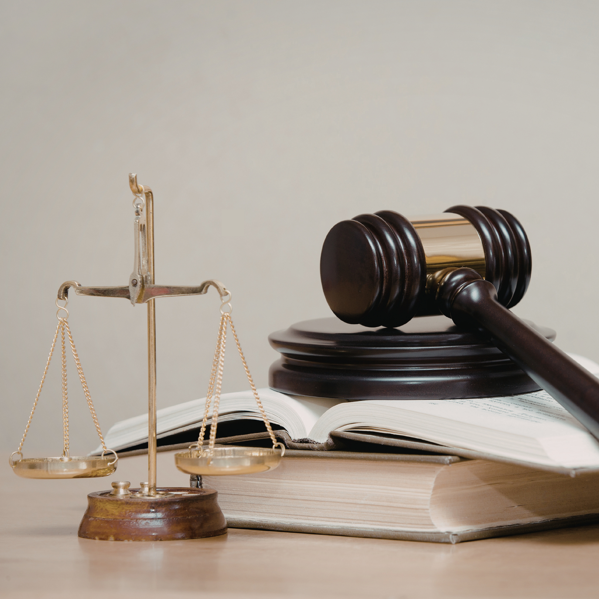 A wooden gavel resting on a law book next to a small model house, symbolizing the legal protection and zoning advocacy for recovery residences under the Fair Housing Act.