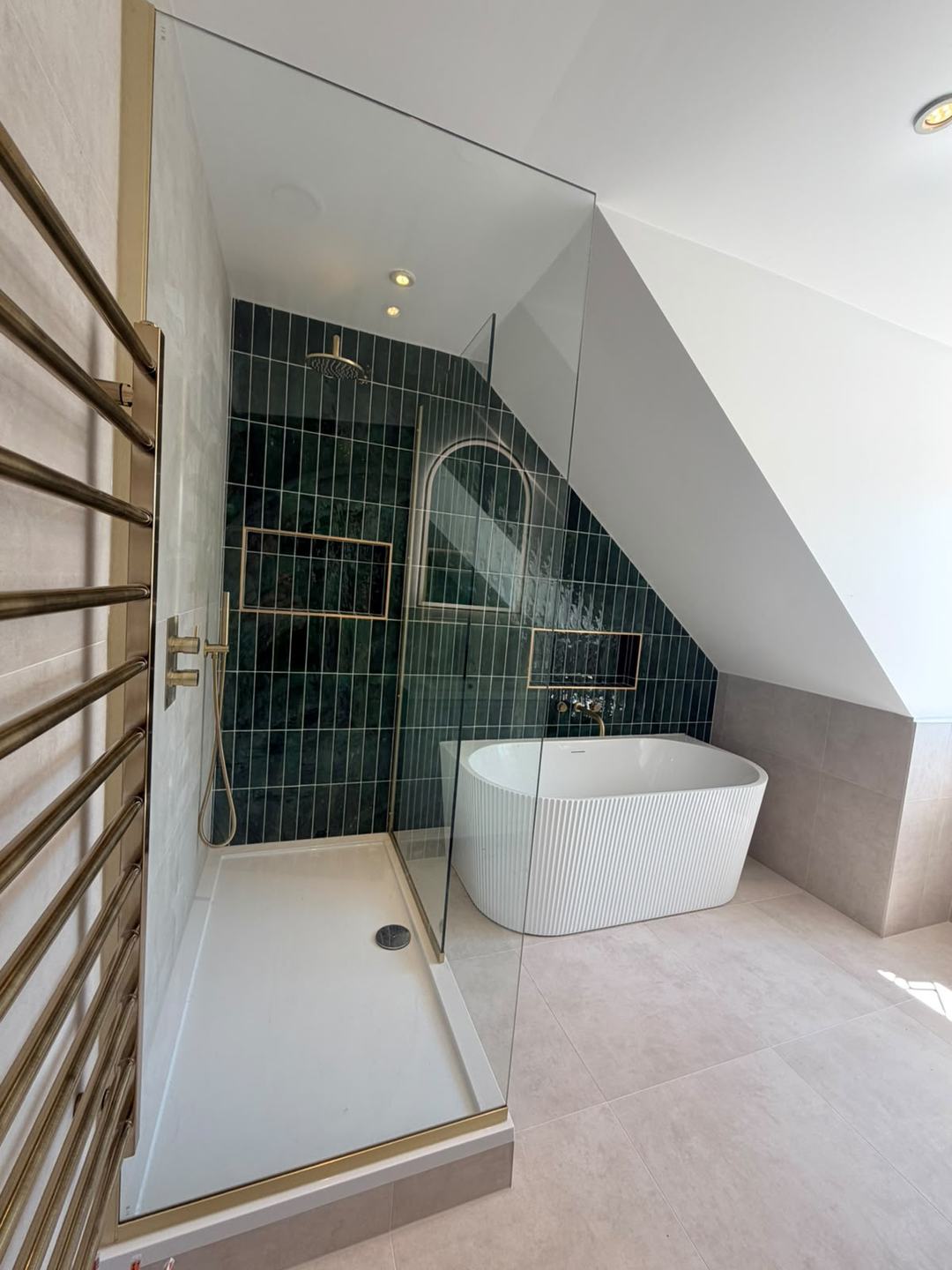 Loft bathroom by Novo Plumbing with green glazed tiles, a walk-in shower and a fluted freestanding bath