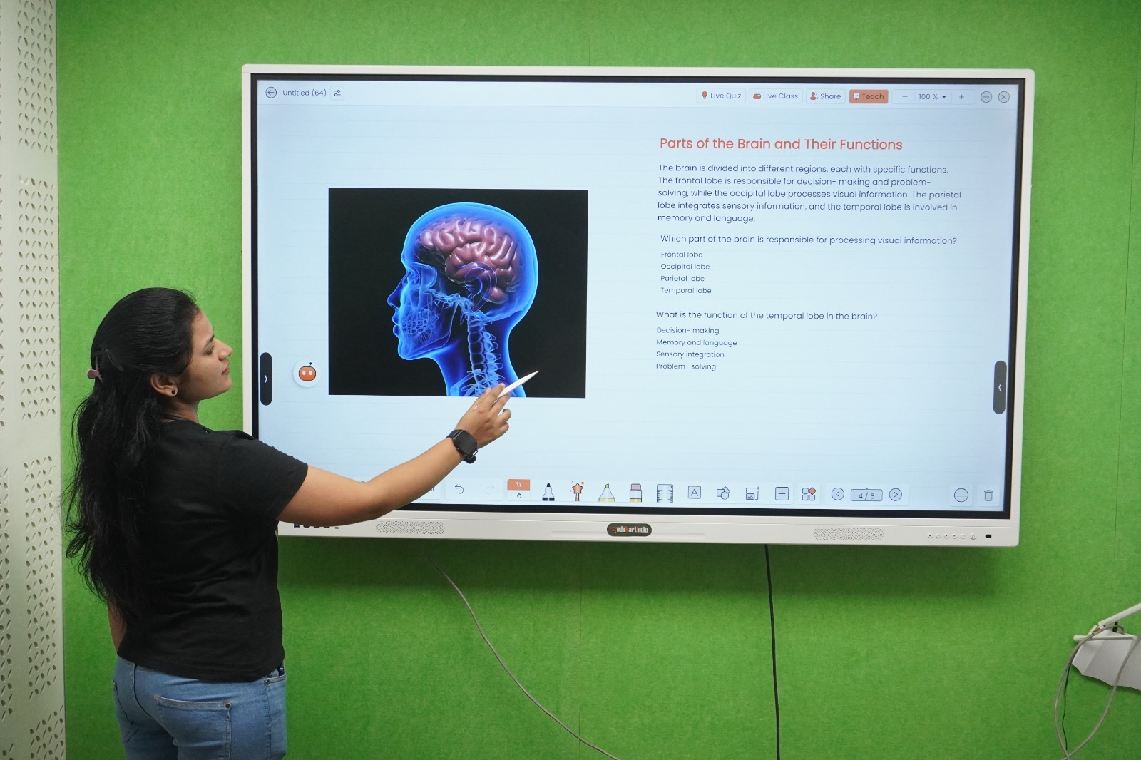 A teacher writing on an Edukartindia interactive flat panel in a classroom
