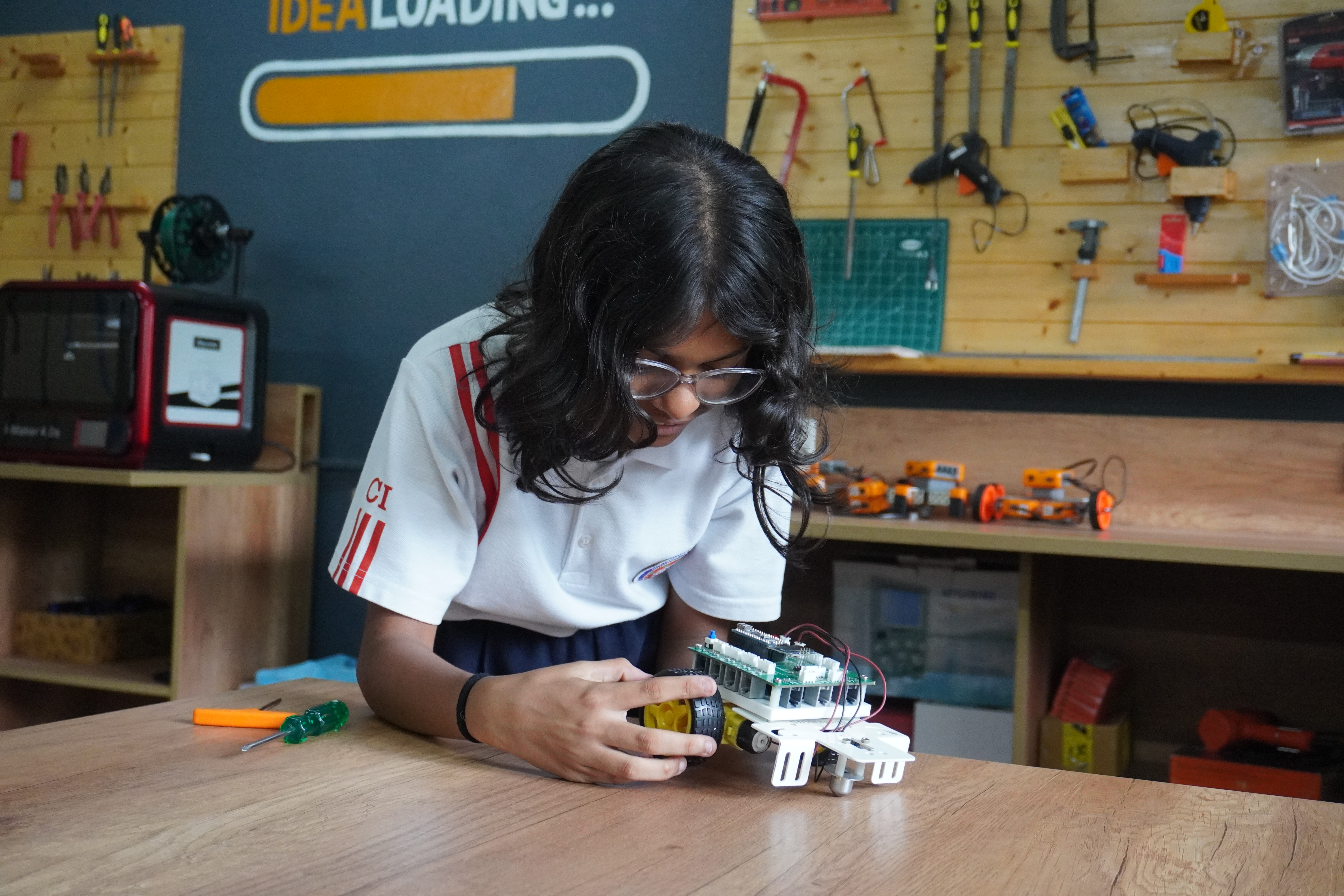 A student building and programming a robot in an AVM–Grobots robotics lab