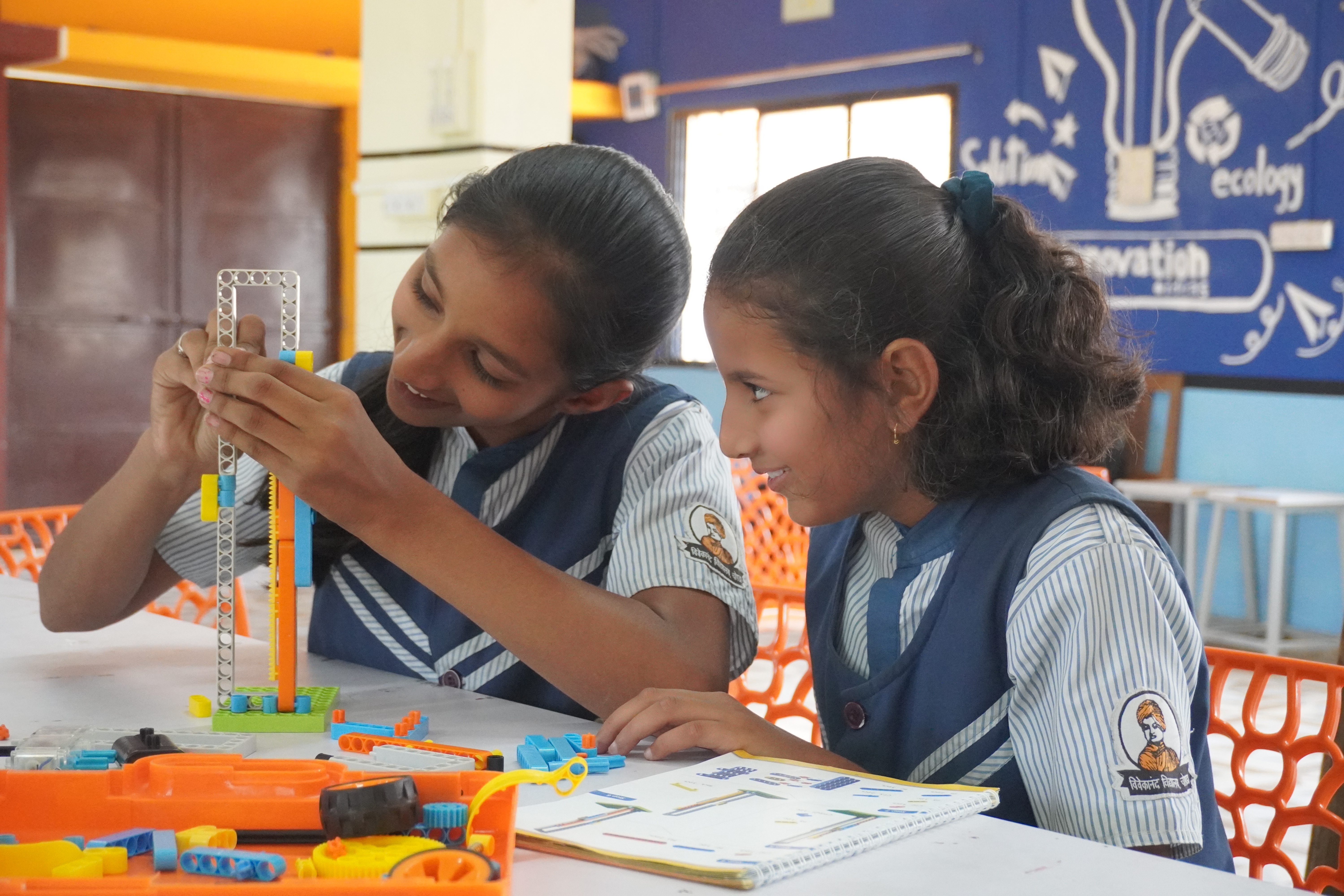Two students building a geared mechanism with the Grobots Junior Robotics Construction Kit