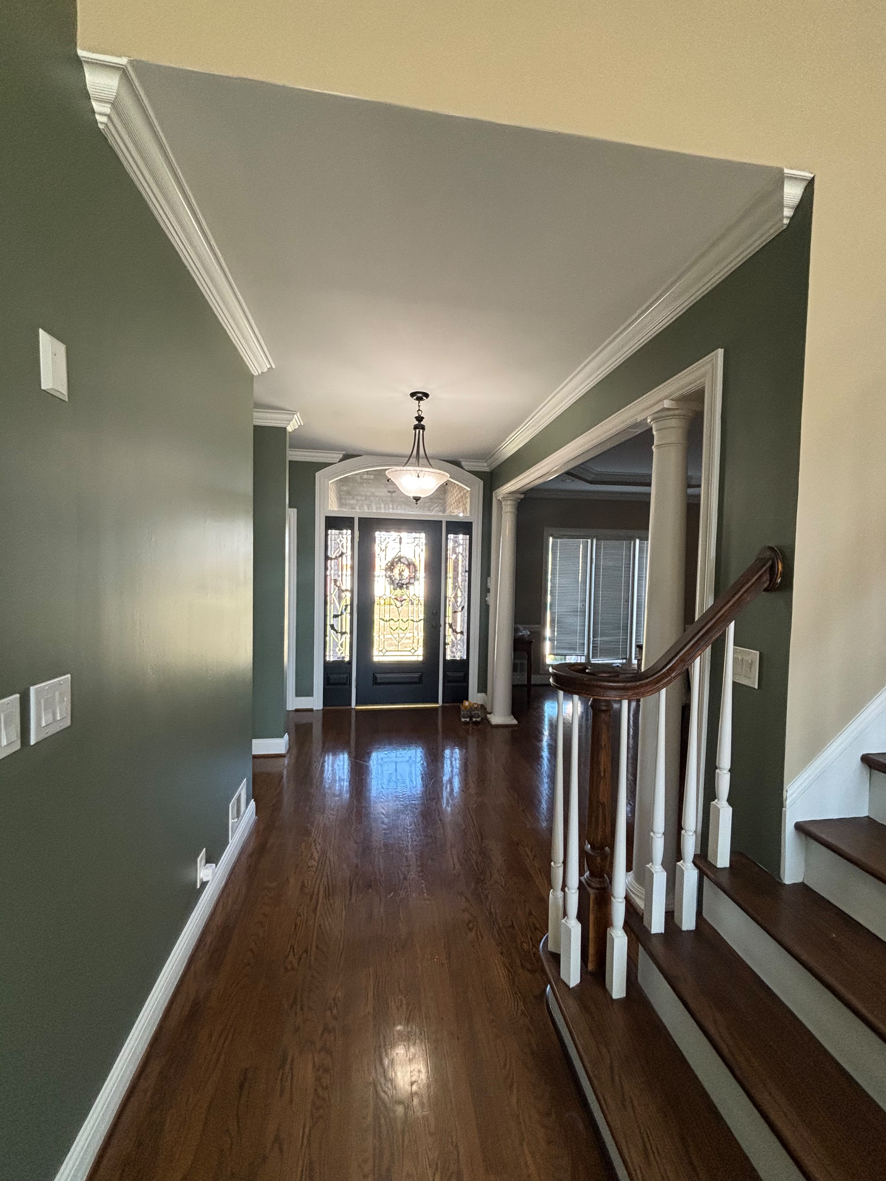 Freshly painted foyer and staircase with clean trim lines in a Louisville KY home by ECH Professional Painting