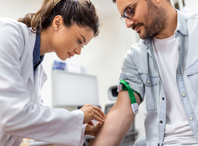 friendly-hospital-phlebotomist-collecting-blood-sample-from-patient-lab-preparation-blood-test-by-female-doctor-medical-uniform-table-white-bright-room-copy