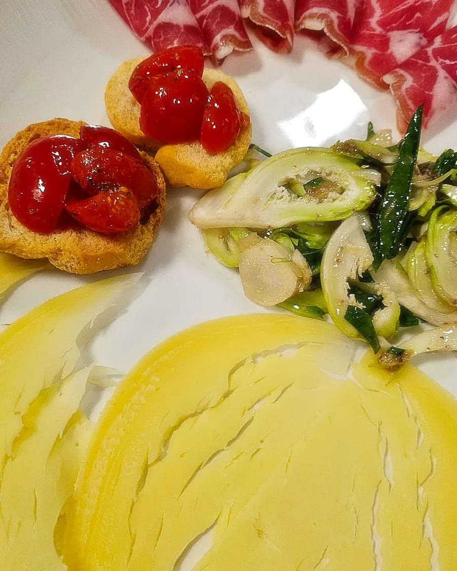 Antipasto con bruschette, pomodorini, verdure e lardo