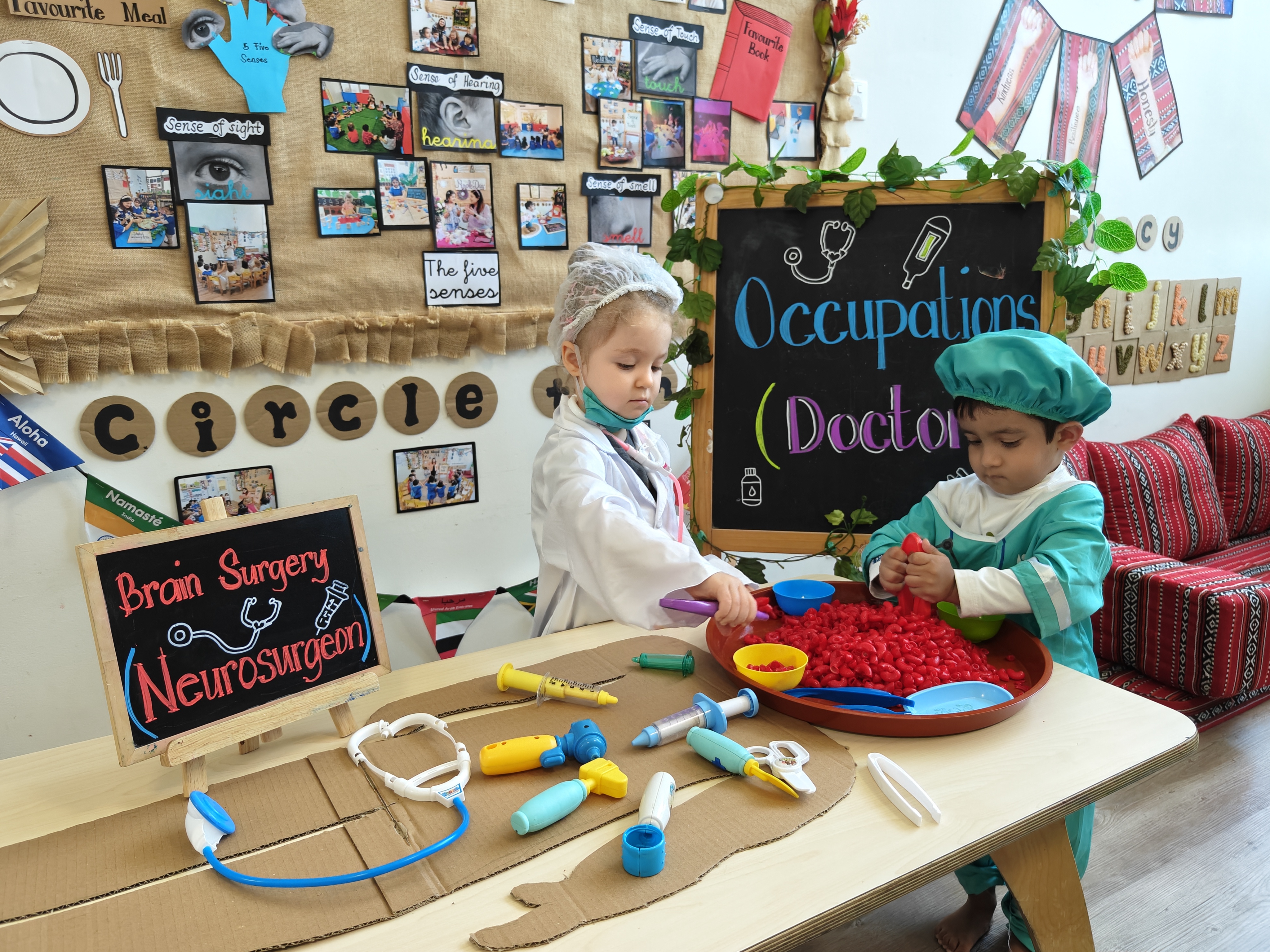 Children engaged in a pretend neurosurgeon role-play activity at Discovery Nursery, using medical props to explore occupations through imaginative play and hands-on learning