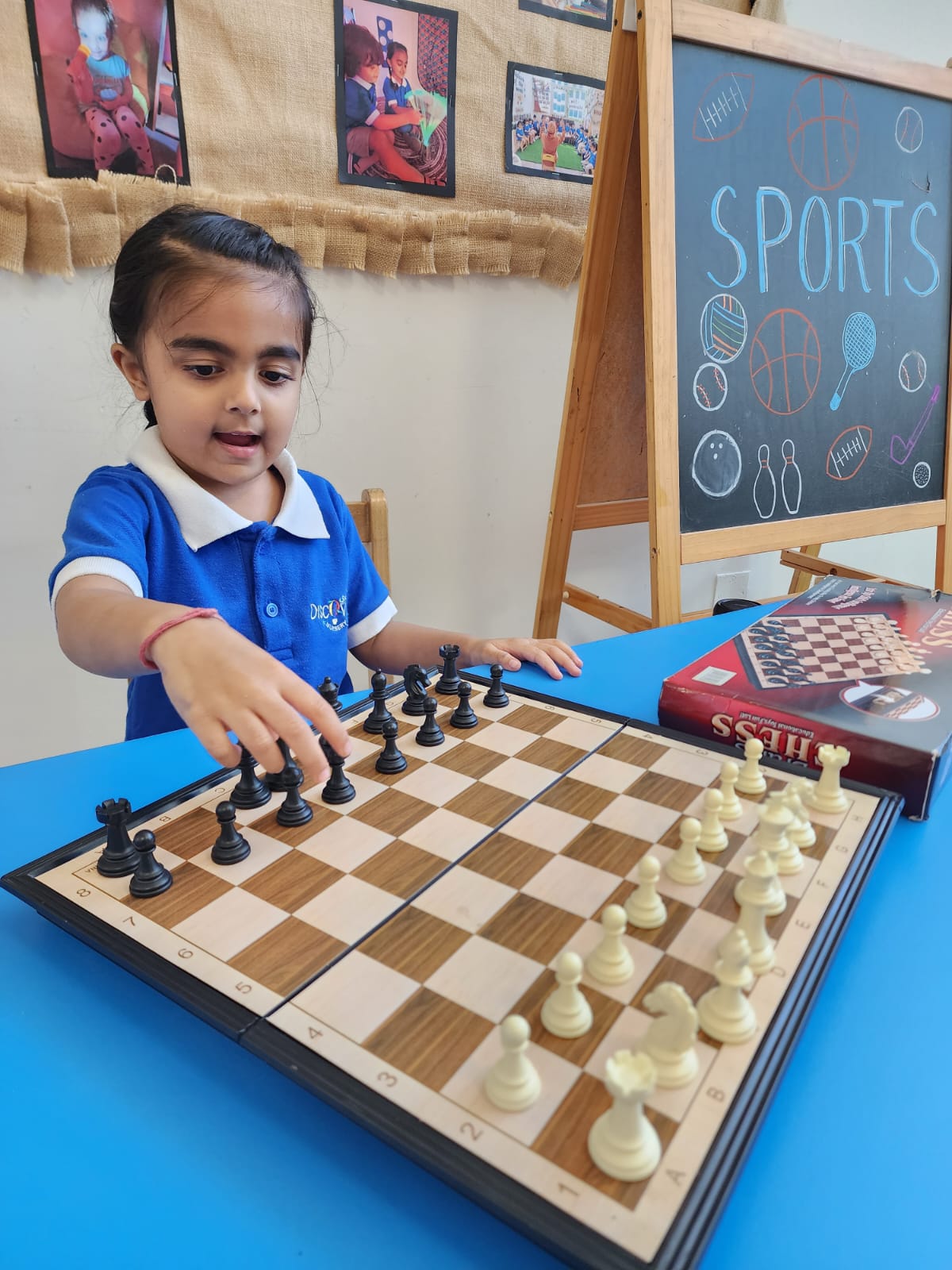 Child developing confidence and decision-making skills while independently exploring a chess game at Discovery Nursery Abu Dhabi